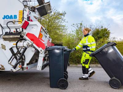 Affaldsmedarbejder der henter affaldsbeholdere ved fortovsindsmaling